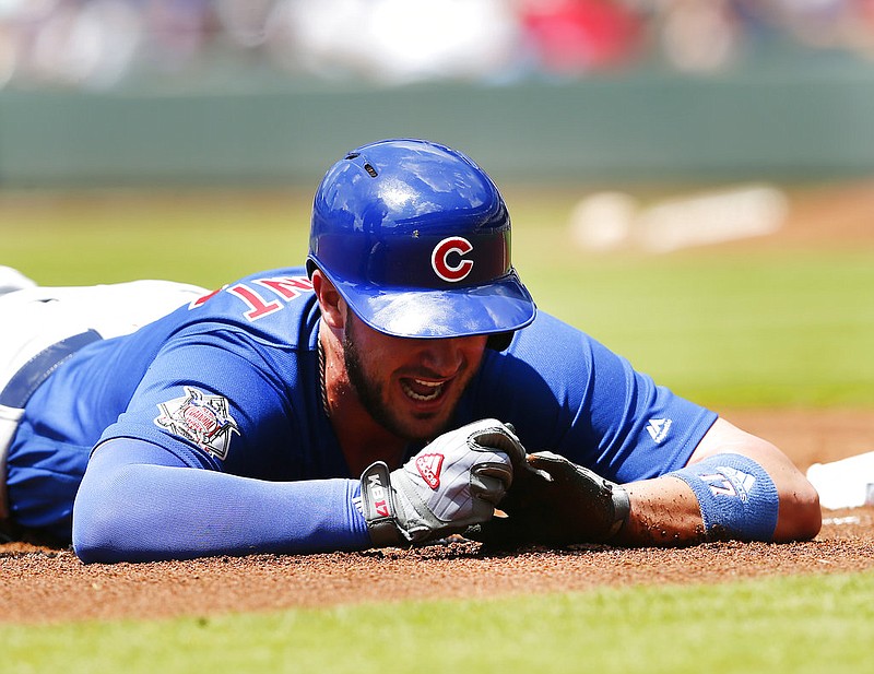 Chicago Cubs third baseman Kris Bryant (17) holds his finger after being injured diving into third base in the first inning of a baseball game against the Atlanta Braves Wednesday, July 19, 2017, in Atlanta.