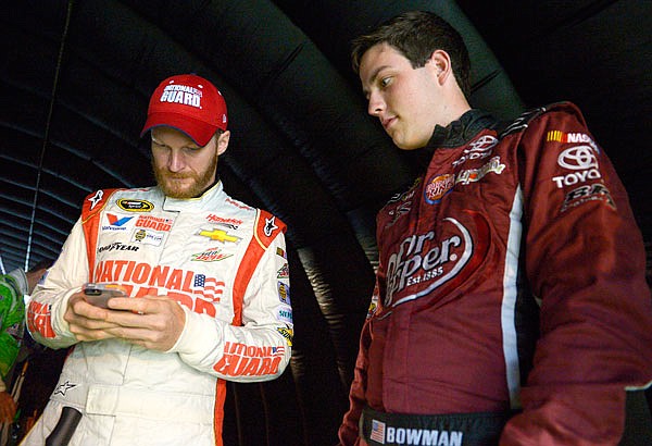 In this July 5, 2014, file photo, Alex Bowman (right) watches as Dale Earnhardt Jr. sends out a tweet while waiting for driver introductions to begin before a NASCAR Sprint Cup Series race at the Daytona International Speedway in Daytona Beach, Fla. 