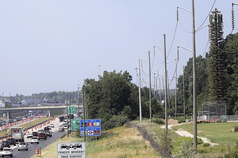 In this July 19, 2017 photo, a cellphone tower that resembles a pine tree can be seen along northbound I-475 Road near Maumee, Ohio. Two looming cell towers in Toledo suburb are now sprouting faux branches to make them look like pine trees and blend in with their surroundings.