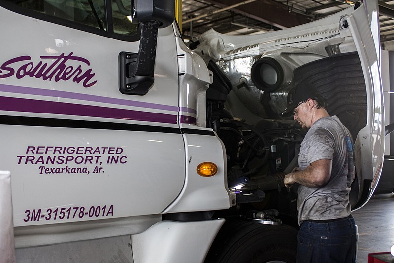 Matthew Sube does maintenance on a truck Tuesday at the Southern Refrigerated Transport facility in Texarkana, Ark.

