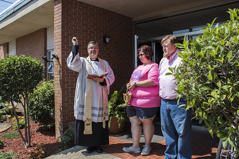 Randy Sams' Outreach Shelter Executive Director Jennifer Laurent and Board President John Delk join Father Douglas Anderson as he blesses the garden Saturday at the new Randy Sams' administration building in Texarkana, Texas.