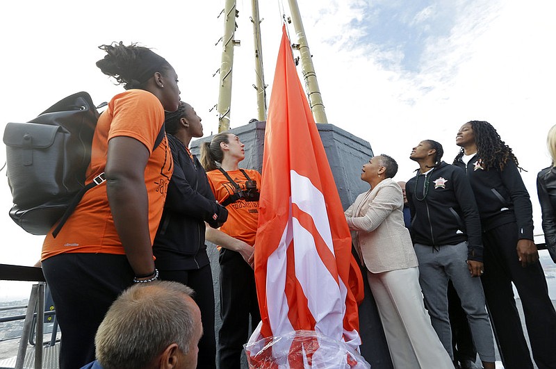 WNBA basketball All-Star players Los Angeles Sparks' Chelsea Gray, from left, and Nneka Ogwumike, Seattle Storm's Breanna Stewart, WNBA president Lisa Borders, Minnesota Lynx's Rebekkah Brunson and Connecticut Sun's Jonquel Jones stand on a platform about 575-feet high atop the Space Needle as they begin to raise the league flag atop the structure Friday, July 21, 2017, in Seattle prior to the WNBA All-Star game Saturday.