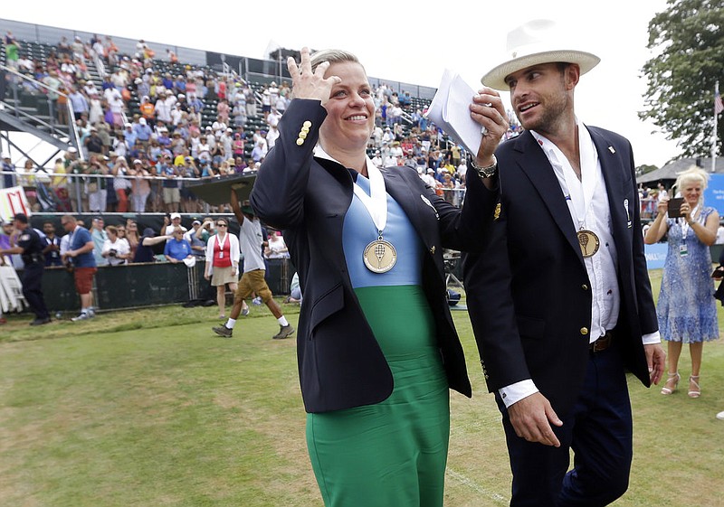 Tennis Hall of Fame inductees Kim Clijsters of Belgium and Andy Roddick of the United States laugh as they walk around center court to acknowledge fans during enshrinement ceremonies at the International Tennis Hall of Fame, Saturday, July 22, 2017, in Newport, R.I. 