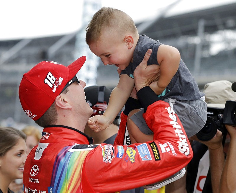 Kyle Busch talks with his son, Brexton, after winning the pole for the NASCAR Cup auto race at Indianapolis Motor Speedway, in Indianapolis on Saturday, July 22, 2017.