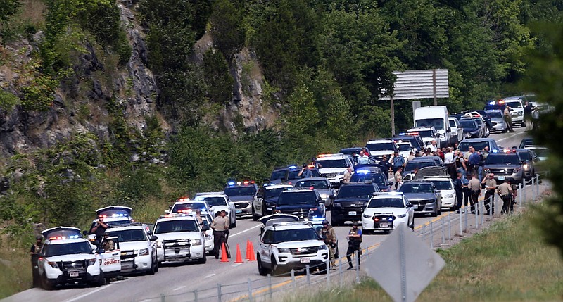 Police cars gather at the scene of a standoff on Interstate 55 near Highway 61 on Monday, July 24, 2017, in Jefferson County Mo. Authorities say a carjacking suspect died Monday after a shootout with police on a busy stretch of interstate near St. Louis.
