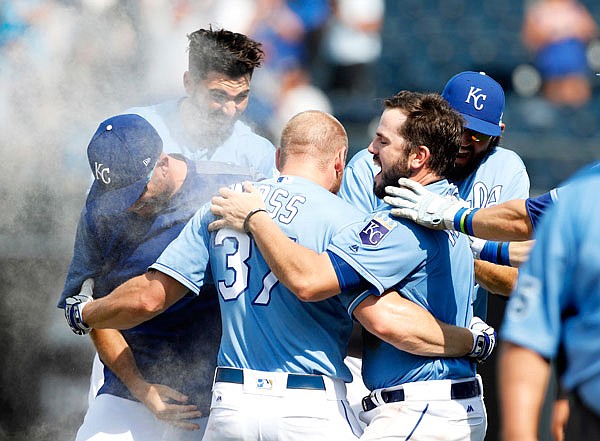 Royals designated hitter Brandon Moss (center) celebrates with Mike Moustakas (right) Eric Hosmer (top left) and other teammates after hitting in the game-winning run in the ninth inning of Sunday afternoon's game against the White Sox at Kauffman Stadium in Kansas City.