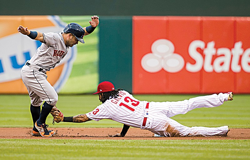 Houston Astros' Jose Altuve, left, tries to get away from a tag by Philadelphia Phillies shortstop Freddy Galvis after he overran second base during the first inning Monday in Philadelphia. Altuve was out on the play.