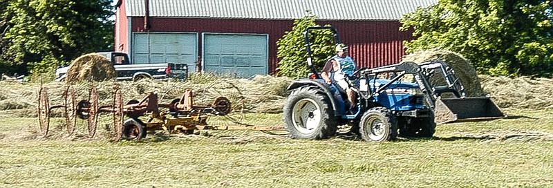 <p>Democrat photo / David A. Wilson</p><p>Tyler Clenin operates a tractor raking hay in rows ready to be picked up by a baler. The hay was cut earlier and allowed to dry.</p>
