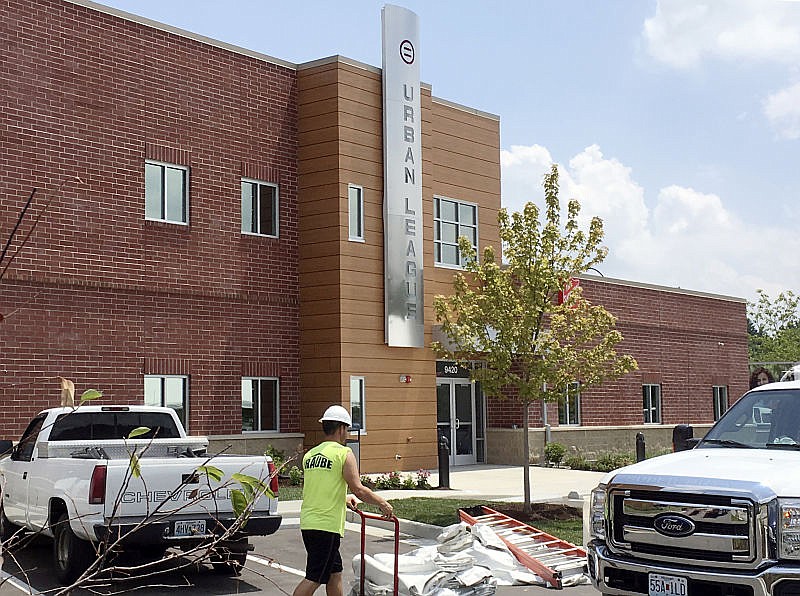 In this Tuesday, July 25, 2017, photo, a construction worker helps with finishing touches at the new Ferguson Empowerment Center in Ferguson, Mo. The new $3 million center will house an Urban League office focused on job training and placement. A dedication ceremony is planned Wednesday morning, July 26.