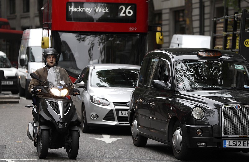 Vehicles drive in central London, Wednesday, July 26, 2017. To control air pollution, new diesel and petrol cars and vans could be banned in the UK from 2040. (AP Photo/Kirsty Wigglesworth)