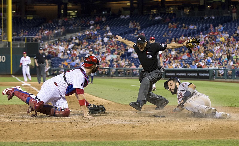 Houston Astros' Marwin Gonzalez, right, is called safe at home by umpire Dan Iassogna, center, as Philadelphia Phillies catcher Cameron Rupp, left, looks on during the sixth inning of a baseball game, Tuesday in Philadelphia. The Astros won 5-0.
