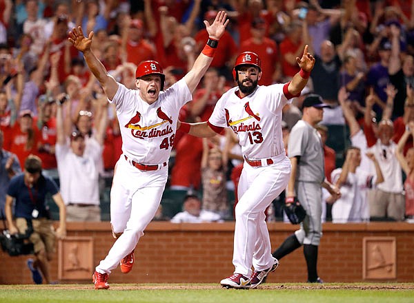 Cardinals teammates Harrison Bader (left) and Matt Carpenter celebrate after Bader scored the game-winning run during the ninth inning of Tuesday night's game against the Rockies at Busch Stadium.