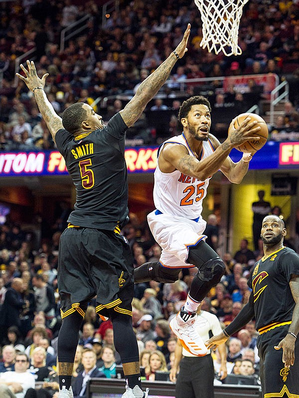 In this Oct. 25 file photo, Knicks' Derrick Rose (25) drives past Cavaliers' J.R. Smith (5) as LeBron James watches during a game in Cleveland. 