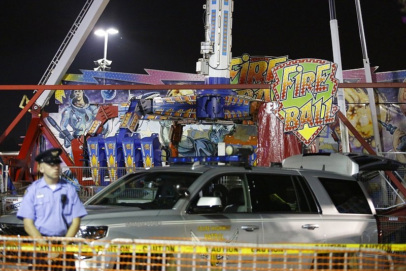 Authorities stand near the Fire Ball amusement ride after the ride malfunctioned, killing one male rider and injuring several others, at the Ohio State Fair, Wednesday, July 26, 2017, in Columbus, Ohio. (Barbara J. Perenic/The Columbus Dispatch via AP)