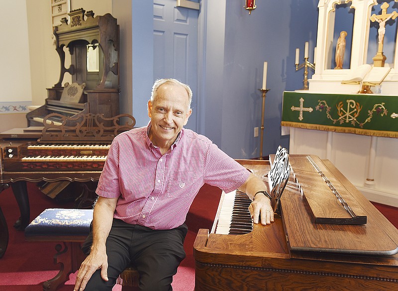 Rev. Gerald Scheperle is seated at one of several antique reed organs in St. John's Lutheran Church in Schubert. There will be an antique reed organ concert Sunday at the church.