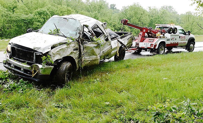 In this May 24, 2016 photo, a tow truck pulls a Ford pickup truck out of the tree line along U.S. 54 south of Holts Summit after the pickup driver lost control on the rain-slick highway. A safety application called High Friction Surface Treatment is being installed on the highway lanes at this location during road work July 31-Aug. 4, 2017.