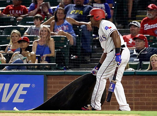 Adrian Beltre of the Rangers drags the on deck circle toward himself after being told by the home plate umpire to get back to the circle during the eighth inning of Wednesday night's game against the Marlins in Arlington, Texas. Crew chief Gerry Davis ejected Beltre after that action.