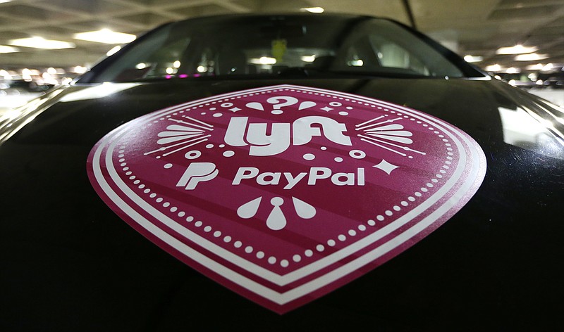 In this March 31, 2016 photo, a Lyft ride-hailing service logo is displayed on a vehicle at Seattle-Tacoma International Airport in Seattle. (AP Photo/Ted S. Warren, File)