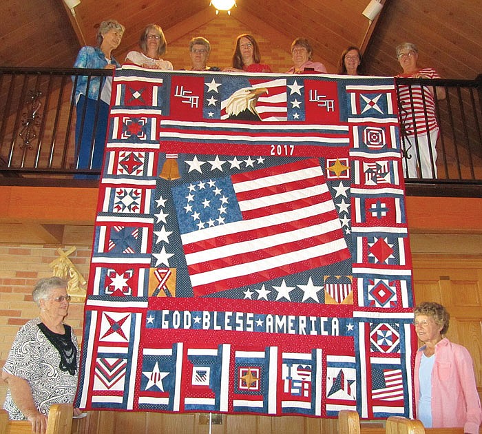 The group of quilters at St. Margaret Church in Osage Bend hope their patriotic quilt will fetch a premium price at Sunday's church picnic. Some of the quilters pictured here are (top, from right): Elane Schmidt, Darlene Wolken, Hilda Schulte, Patti Tappel, Willy Borgmeyer, Marilyn Daledovich and Janet Koetting. At bottom from left are Anna Marie Braun and Odelia Schmidt.