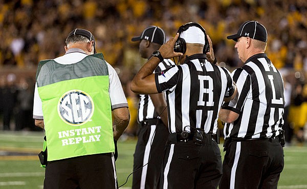 In this Sept. 10, 2016, file photo, referees gather to review a play during the second quarter of an game between Eastern Michigan and Missour at Faurot Field. College football is the latest sport to take steps in an attempt to shorten the times of their games.