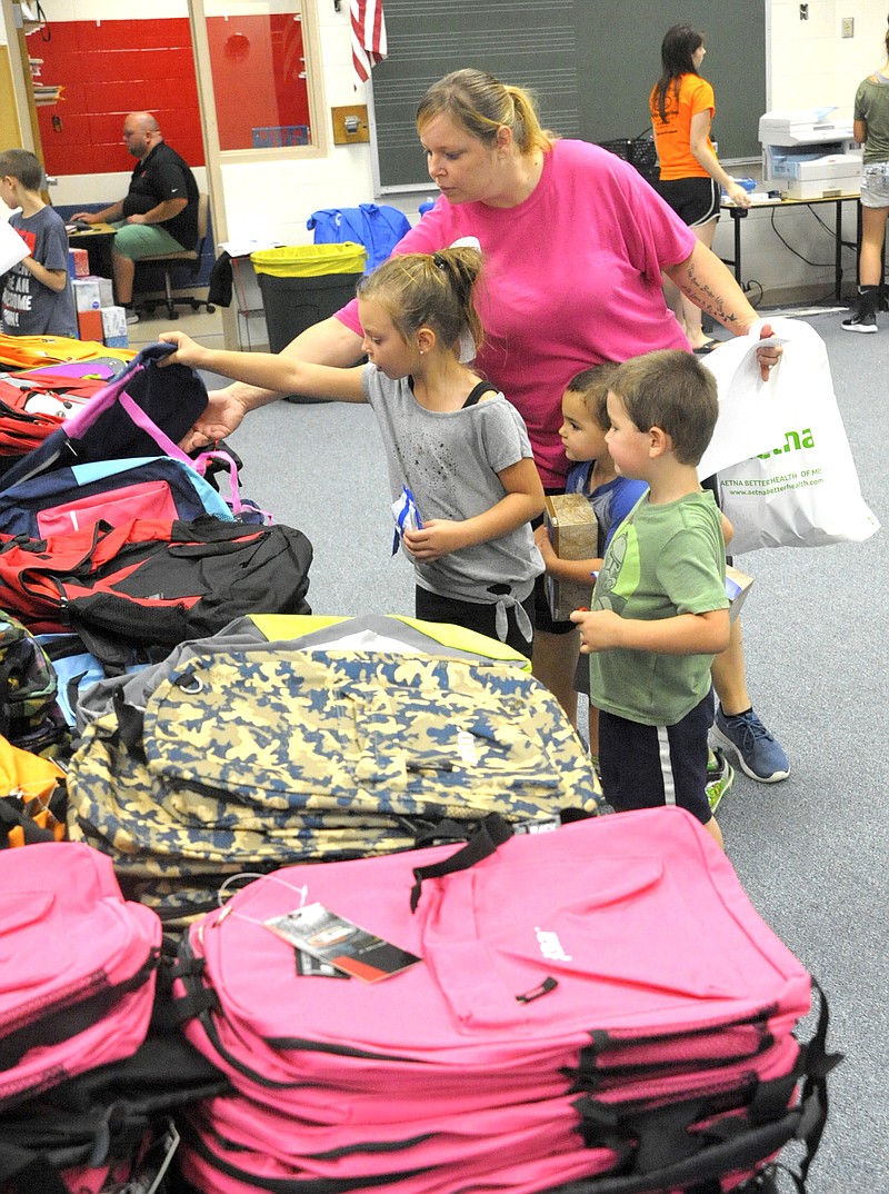 <p>Michelle Brooks/News Tribune</p><p>More than 500 students registered to pick up school supplies Aug. 1 at the Moniteau County Alliance for Kids Back-to-School Fair. Keoni Phouangsyvanith, 7, picked a new backpack and filled it with supplies, as well as a bag of hygiene items. She was helped by her mother, Brandy, and brothers, Kaison, 4, and Holden, 2.</p>