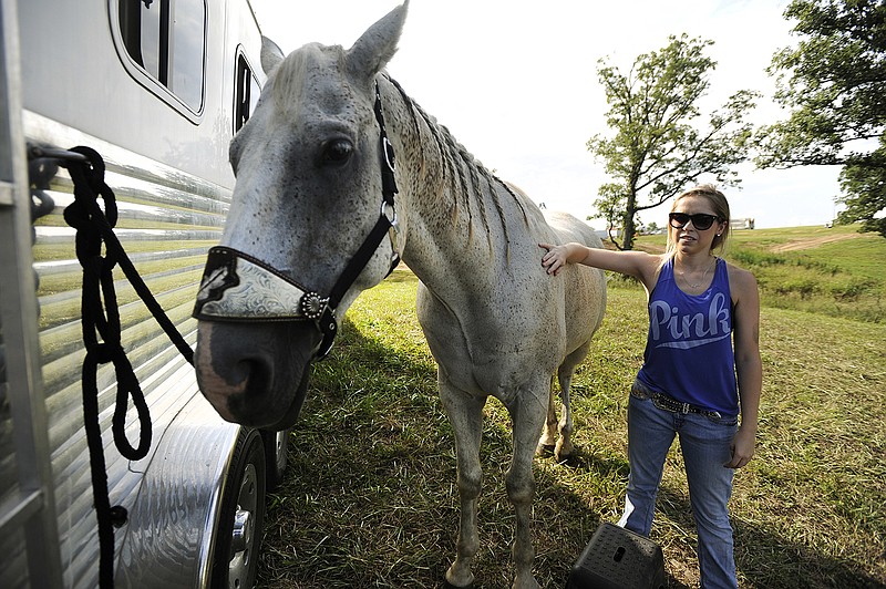 Shelby Newberry pets her horse, Decan, while preparing Monday for the Glory Days Rodeo during the Jefferson City Jaycees Cole County Fair. Newberry and Decan primarily do roughstock and barrel racing competitions. 