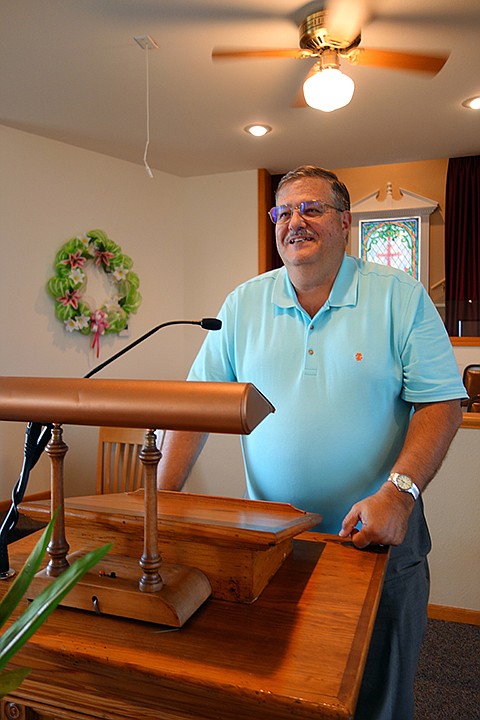 Fifth-year Elston Baptist Church Pastor David Fitzgerald stands before the pulpit Wednesday, Aug. 2, 2017, before an evening prayer group.