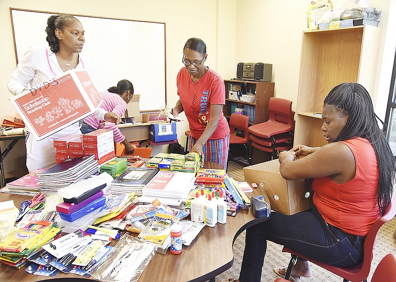 From left, Darlene Wells, Jacqueline Stewart, Virginia Burries and Tammie Smith, all involved in the Jefferson City Family Self-Sufficiency or FSS Program, volunteered their services to organize donated school supplies collected by Table of Grace Christian Church. As part of their outreach service, they spent their morning counting and sorting pens, pencils, note pads, binders and more. Table of Grace is expecting more donations after which filled backpacks will be given out to those who pre-registered for the back-to-school assistance program.