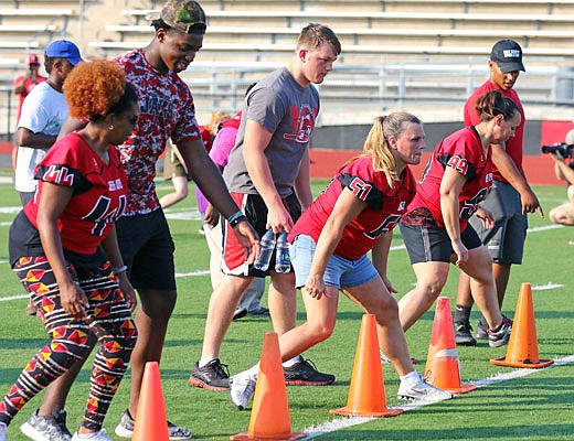 Defensive linemen (from left) Corey Suttle, Brandon Backues and Nick Williams instruct their moms during Jefferson City Jays Mom's Night on Wednesday at Adkins Stadium.