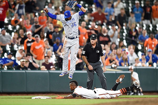 Tim Beckham of the Orioles slides safely under Royals third baseman Ramon Torres with an RBI triple during the eighth inning of Wednesday night's game in Baltimore.