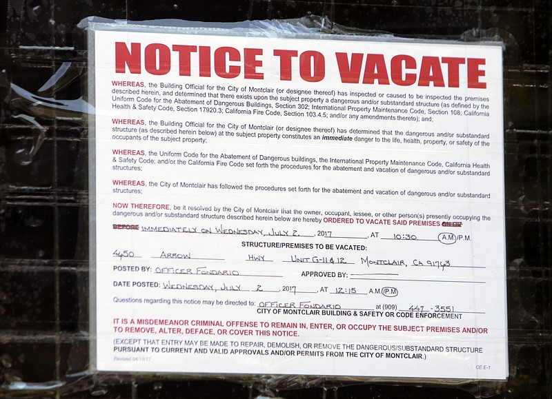 The notice to vacate is posted on the front door of Unit G-11 and G-12 after the Inland Valley Humane Society workers removed animals some alive and dead, from a warehouse Friday, Aug. 4, 2017 in Montclair, Calif. Montclair police stumbled across a trash-strewn industrial building crammed with more than 1,000 snakes, parrots, chickens and other exotic animals when they arrived to serve an arrest warrant on a man there.  (Terry Pierson/Los Angeles Daily News via AP)