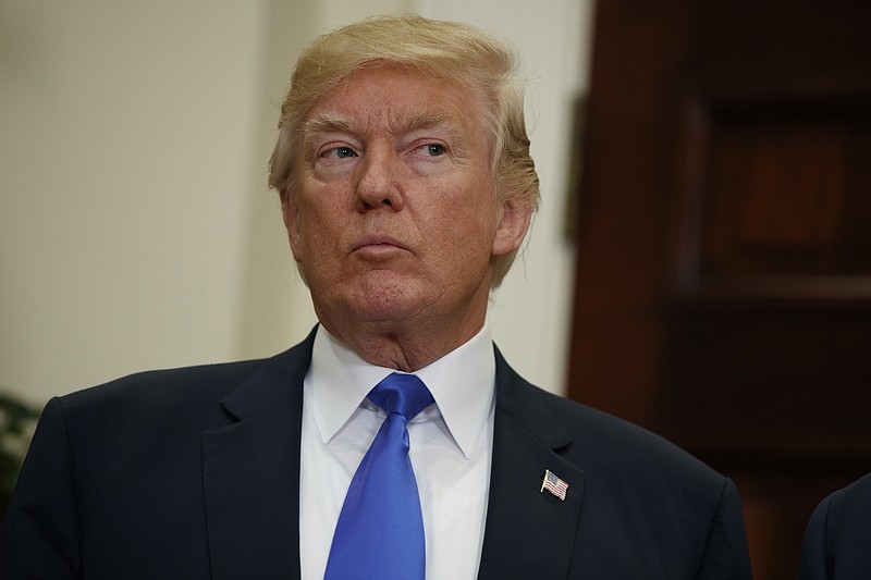 FILE - In this Aug. 2, 2017 file photo, President Donald Trump listens in the Roosevelt Room of the White House in Washington. In populist tones, President Donald Trump is trying to turn the investigation into his campaign's ties to Russia into a rallying cry, labeling it as an existential threat to the loyal base that fueled his surprise 2016 election triumph.  (AP Photo/Evan Vucci, File)