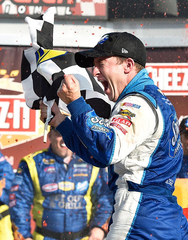 In this Aug. 10, 2014, file photo, AJ Allmendinger waves the checkered flag as he celebrates in victory lane after winning a NASCAR Sprint Cup race at Watkins Glen International in Watkins Glen, N.Y.