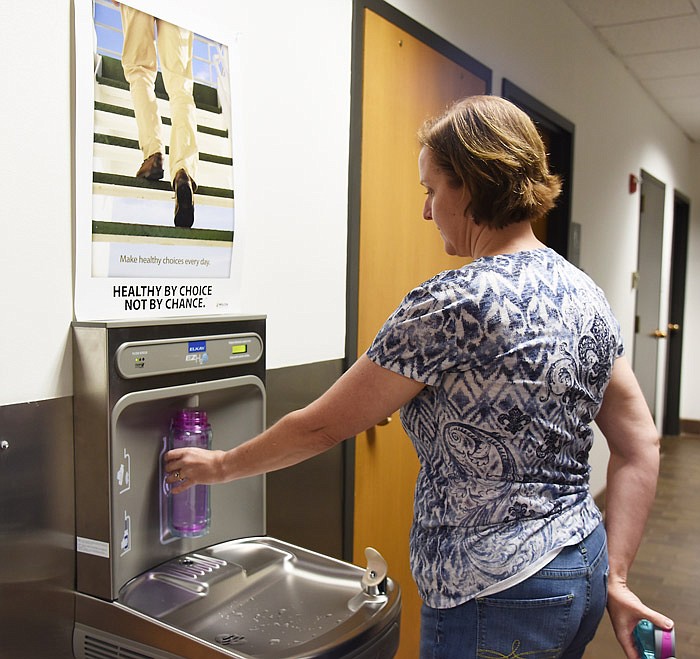 Ann Stratman refills a water bottle Friday, Aug. 4, 2017 on the first floor of Jefferson City Hall, where the city has installed water energy efficient water stations that feature a counter that displays how many plastic bottles worth of water have been refilled using this system.