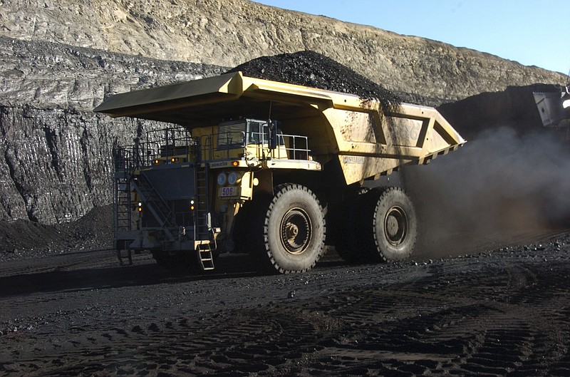 FILE - In this Nov. 15, 2016, file photo, a haul truck with a 250-ton capacity carries coal from the Spring Creek strip mine near Decker, Mont. As President Donald Trump touts new oil pipelines and pledges to revive the nation’s struggling coal mines, federal scientists are warning that burning fossil fuels is already driving a steep increase in the United States of heat waves, droughts and floods. (AP Photo/Matthew Brown, File)