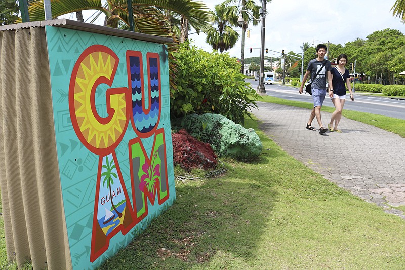 In this May 15, 2017, file photo, tourists walk through a shopping district in Tamuning, Guam. Security and defense officials on Guam said on Aug. 9, 2017, that there is no imminent threat to people there or in the Northern Mariana Islands after North Korea said it was examining its operational plans for attack. (AP Photo/Haven Daley, File)