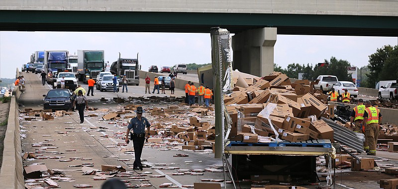 Arkansas State Police investigate after a truck hauling frozen pizza got hit by a car causing Interstate 30 to be shut down on Wednesday, Aug. 9, 2017, in Little Rock, No injuries were reported from the wreck.