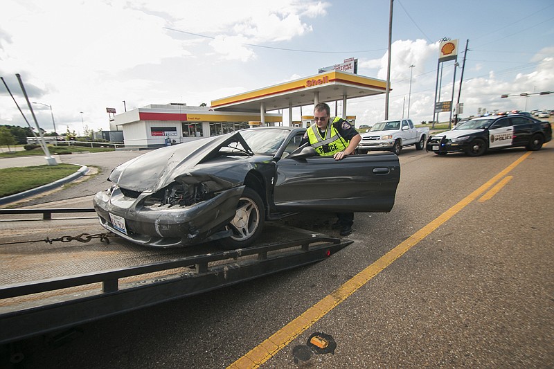 A Texarkana, Texas, police officer helps steer a car to be towed Wednesday following a two-vehicle wreck that happened shortly after 4 p.m in front of a Shell gas station on Summerhill Road. A Mazda Tribute pulled out of the gas station and in front of a Ford Mustang traveling south on Summerhill. The driver of the Tribute was sent to CHRISTUS St. Michael with minor injuries. 