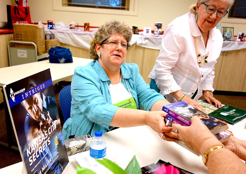 Romantic suspense author Julie Miller, left, signs books Thursday after her talk at the Callaway County Public Library. Her mother, Barbara Binger, of Fulton, also attended and helped with the book signing.