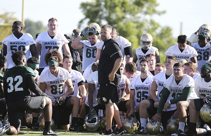 Baylor head football coach Matt Rhule, center, gathers his team in the center of the field following the first day of NCAA college football practice July 27 in Waco, Texas.