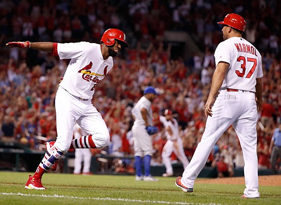 Dexter Fowler is congratulated by Cardinals first base coach Oliver Marmol after hitting a grand slam off Royals relief pitcher Neftali Feliz during the seventh inning of Thursday's game at Busch Stadium.