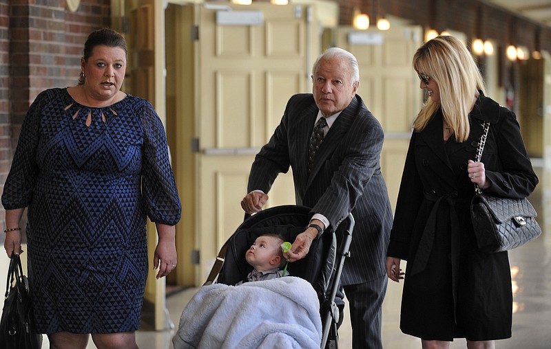 FILE - In this March 17, 2014 file photo, Former Louisiana Gov. Edwin Edwards, center, walks down the hallway pushing his son, Eli, as he is accompanied by wife Trina Scott Edwards, right, and Charlotte Guedry, left, before speaking at the Baton Rouge Press Club in Baton Rouge, La. Louisiana's four-term former governor Edwards is having an ostentatious 90th birthday bash, Saturday, Aug. 12, 2017, with a $250-per-person price tag to attend. The powerful and charismatic Edwards was the dominant figure in Louisiana politics for decades before he went to federal prison for a corruption conviction. Out of prison for six years, he's got a wife five decades his junior, a 4-year-old son and continued popularity in his home state. (AP Photo/Travis Spradling, File)