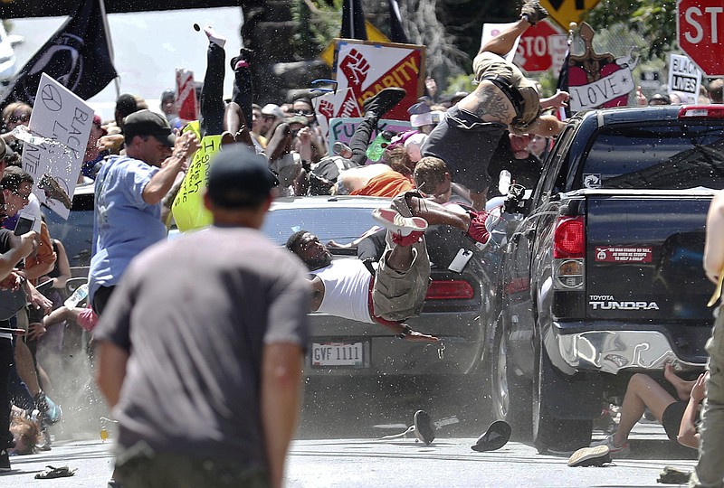 People fly into the air as a vehicle drives into a group of protesters demonstrating against a white nationalist rally in Charlottesville, Va., Saturday, Aug. 12, 2017. The nationalists were holding the rally to protest plans by the city of Charlottesville to remove a statue of Confederate Gen. Robert E. Lee. There were several hundred protesters marching in a long line when the car drove into a group of them. (Ryan M. Kelly/The Daily Progress via AP)