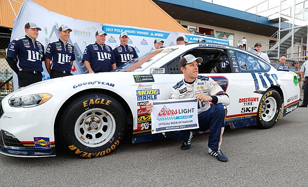 Brad Keselowski celebrates Friday after qualifying for the pole for the NASCAR Cup Series race in Brooklyn, Mich.