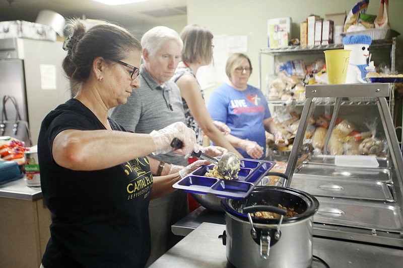 Volunteer Cathy Wylie serves food for the homeless during a community meal last week
at the Salvation Army in Jefferson City.