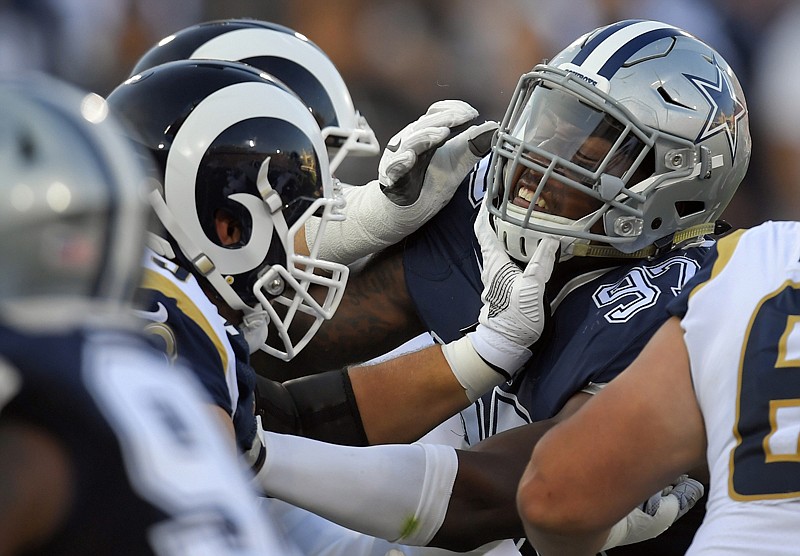 Dallas Cowboys defensive end Taco Charlton, right, gets a hand to the mask from the Los Angeles Rams offensive guard Cody Wichmann during the first half of a preseason NFL football game Saturday in Los Angeles. The Rams won, 13-10.