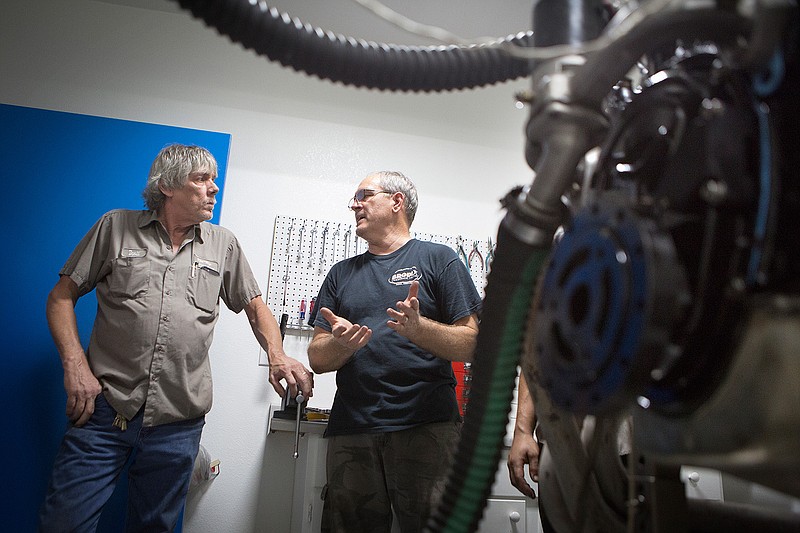 David Purifoy, owner of Purifoy Racing, right, and David Shurtleff discuss the process of extracting maximum horsepower from Shurtleff's sponsored Chevy 350 motor Friday through the use of an engine dynamometer at Purifoy's shop in Genoa Ark. Also known as a dyno, the machine is used to calibrate and measure the power an engine makes by monitoring factors such as fuel, air and temperature. Purifoy Racing has the only engine dyno service in the area.