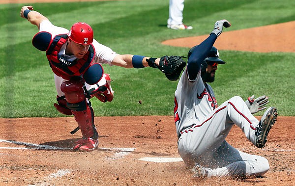 Cardinals catcher Carson Kelly is unable to tag out Nick Markakis of the Braves as he scores on a sacrifice fly by Ozzie Albies in the fourth inning of Sunday afternoon's game at Busch Stadium.