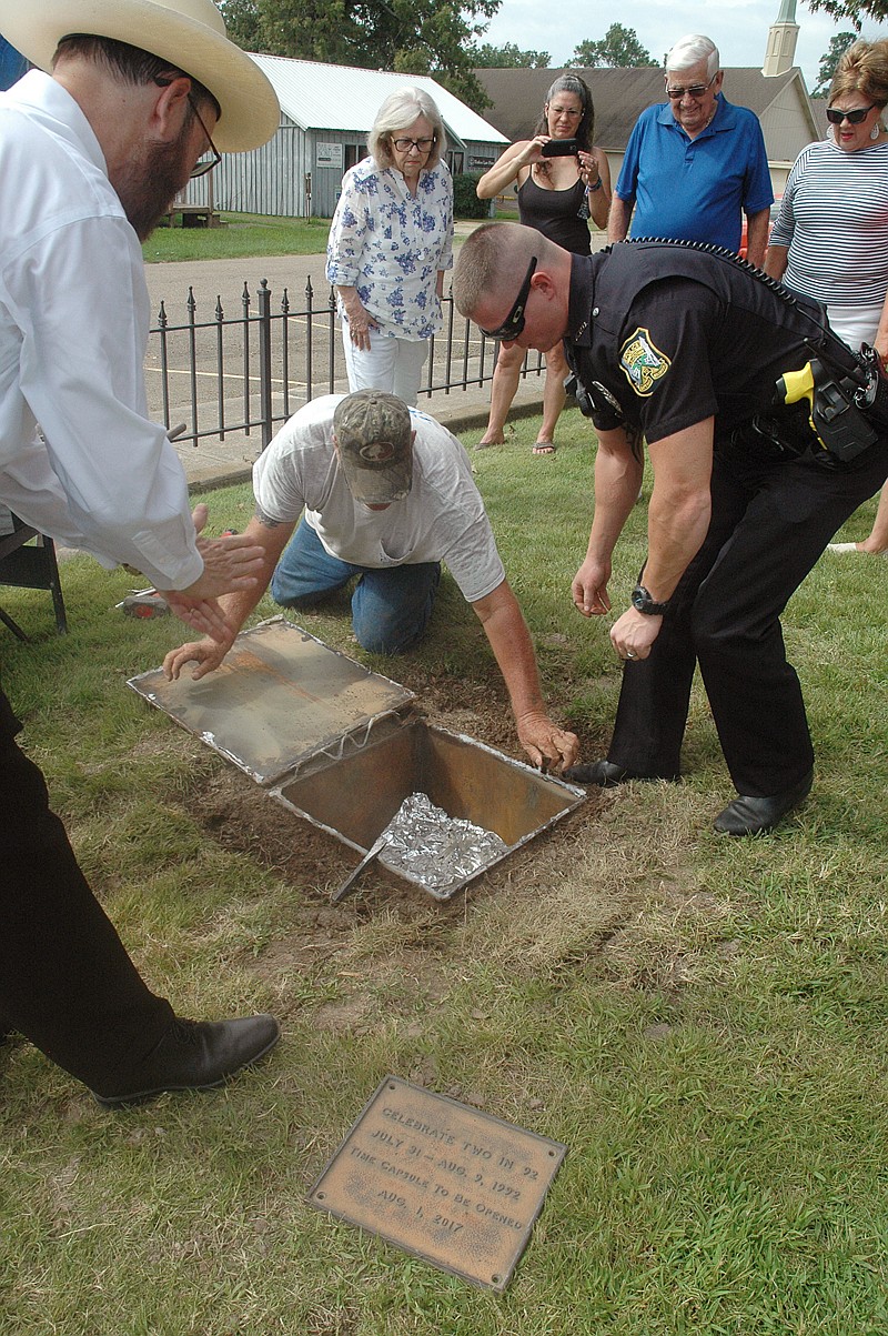 A 25-year-old time capsule was opened Saturday in Ashdown, Ark., on the Little River County Courthouse lawn. Little River County Historical Society President John Finley, left, Tom Knighten, maintenance supervisor; and Ashdown Policeman Kenny Purtell helped remove the 1/2-inch steel lid. Items from the time capsule will be donated to the Two Rivers Museum in Ashdown.