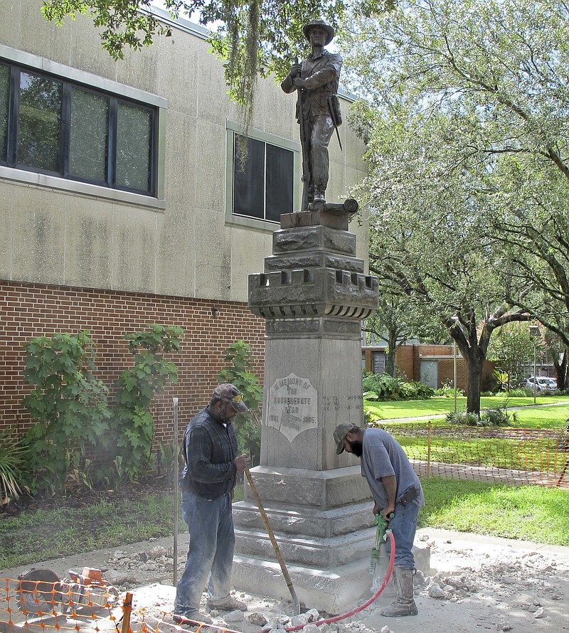 Workers begin removing a Confederate statue in Gainesville, Fla., Monday, Aug. 14, 2017. The statue is being returned to the local chapter of the United Daughters of the Confederacy, which erected the bronze statue in 1904. County officials said they did not know where the statue would be going.